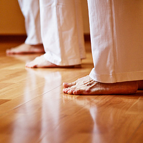 Füße von Yoga-Praktizierenden auf dem Boden stehend
